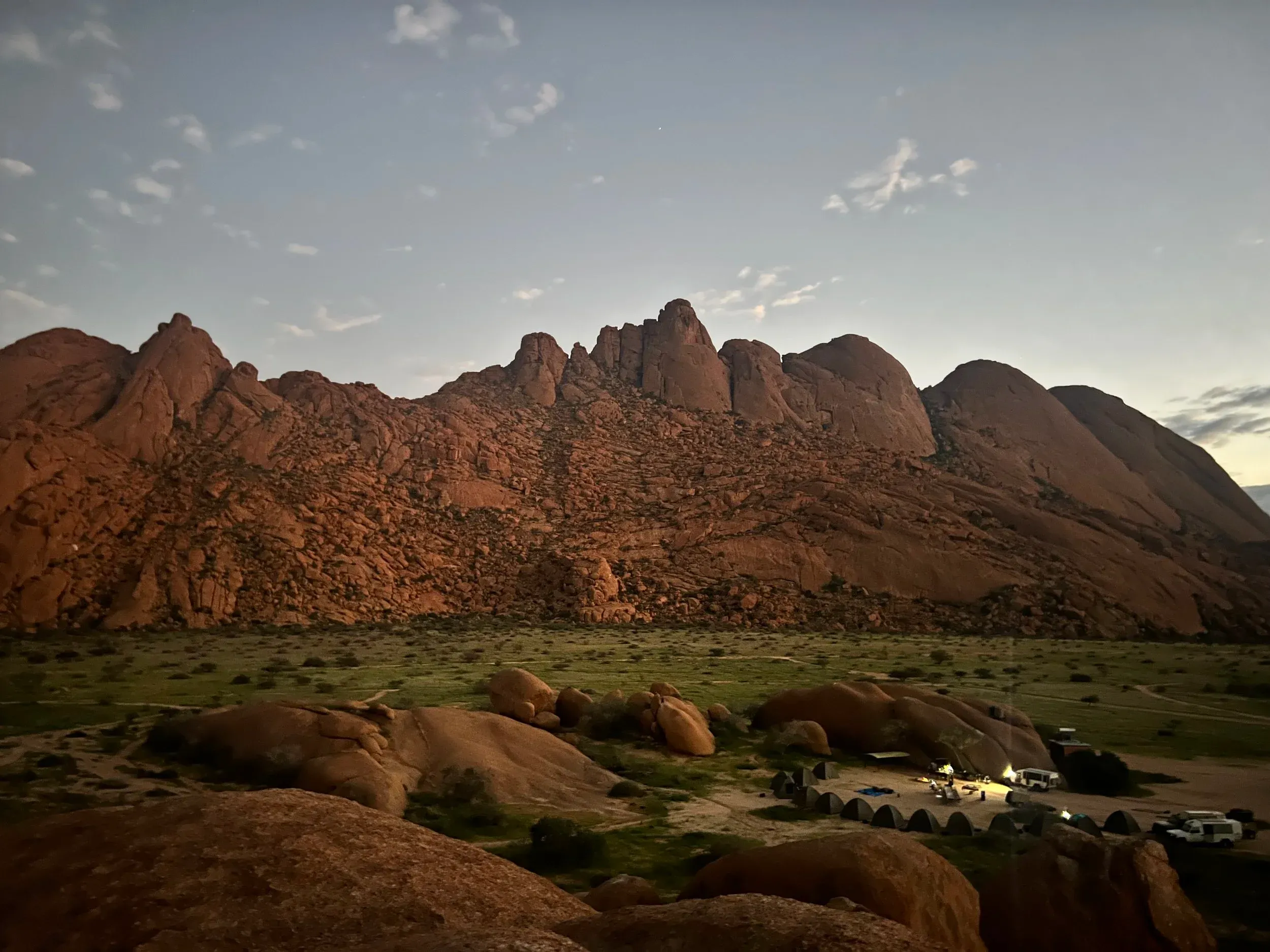 Rocky granite peaks of the Spitzkoppe at dusk with a campsite below