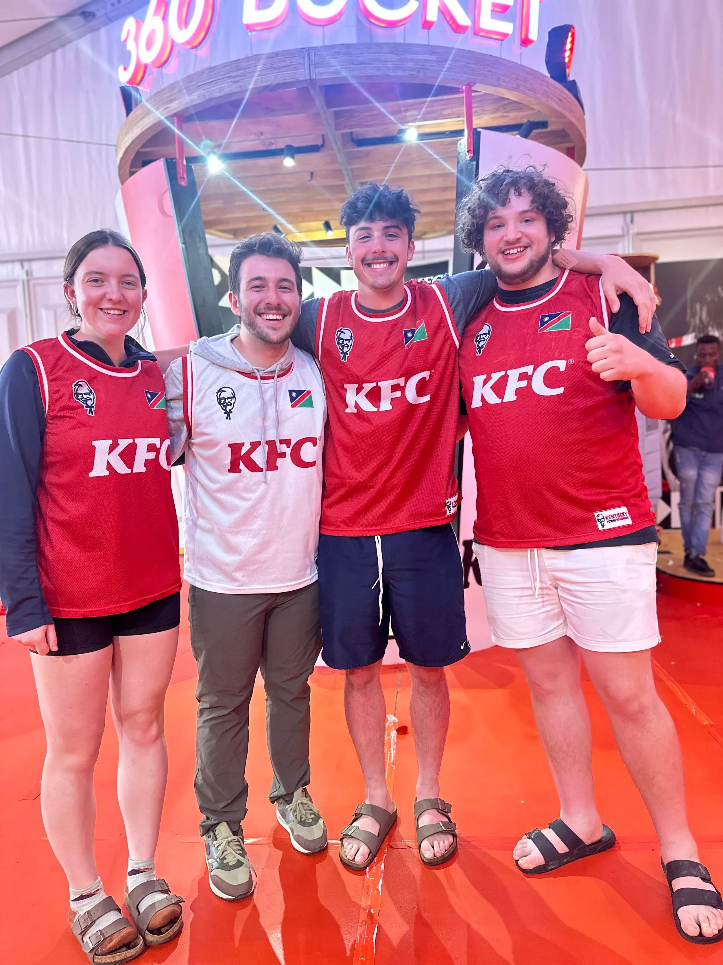 Four friends in red football jerseys at a stadium
